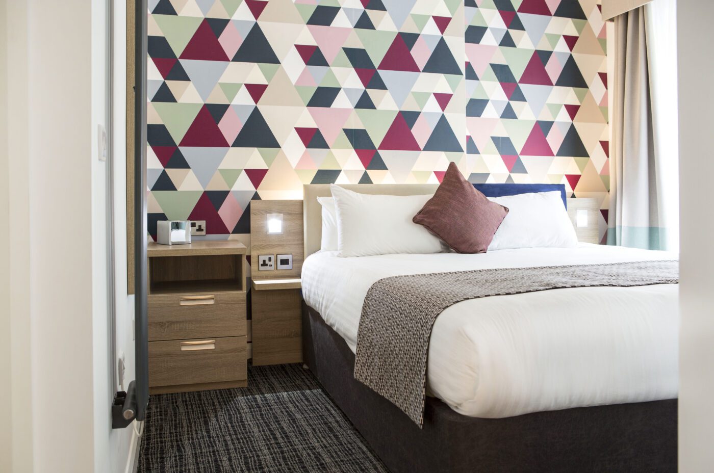 Cityroomz bedroom with a double bed, theme wall and bedside tables.