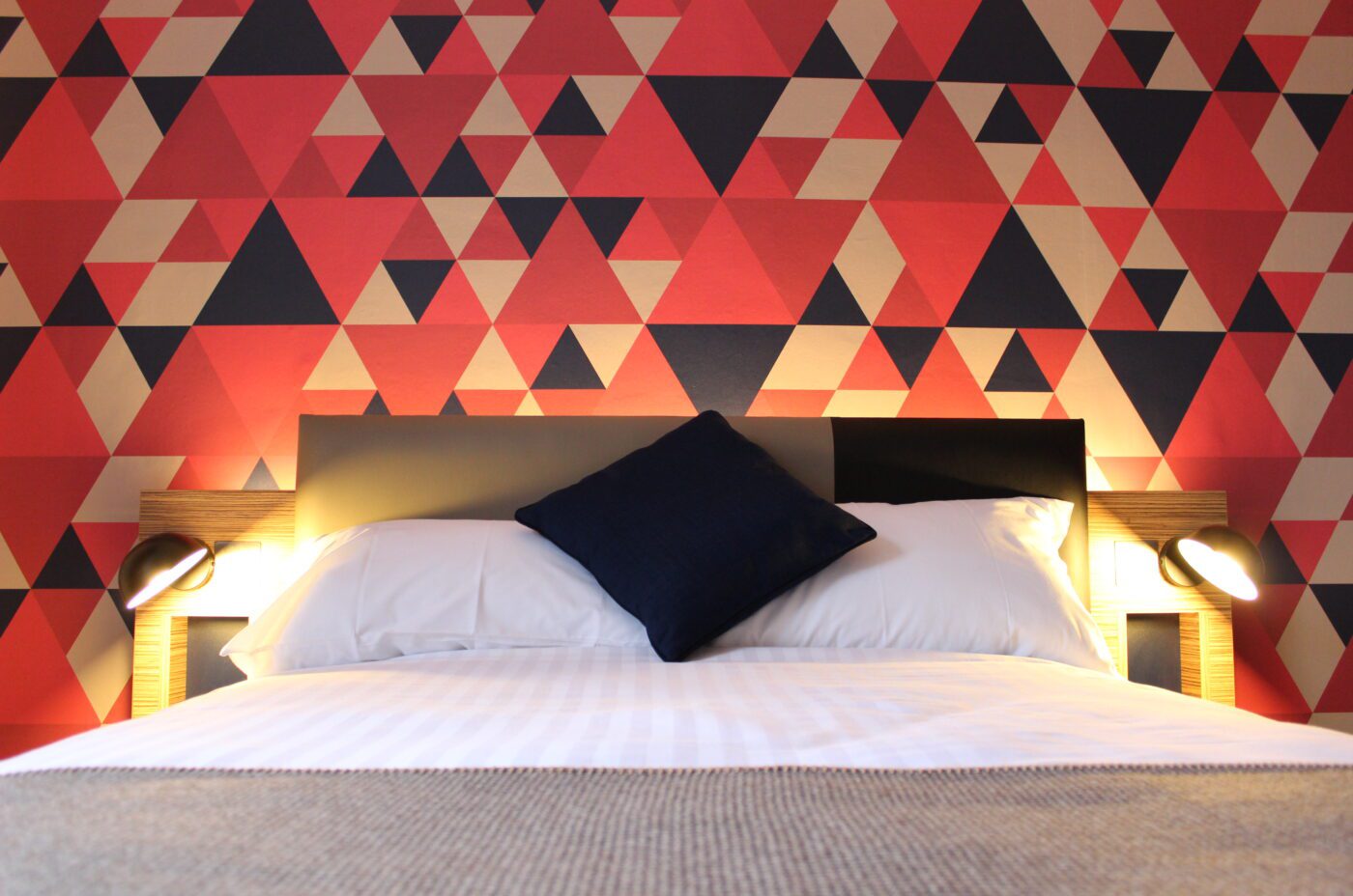 Double bed placed against a theme wall.