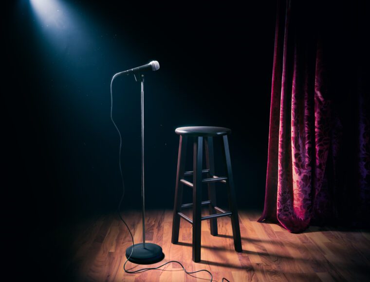 Microphone on a stage with wooden stool at comedy show