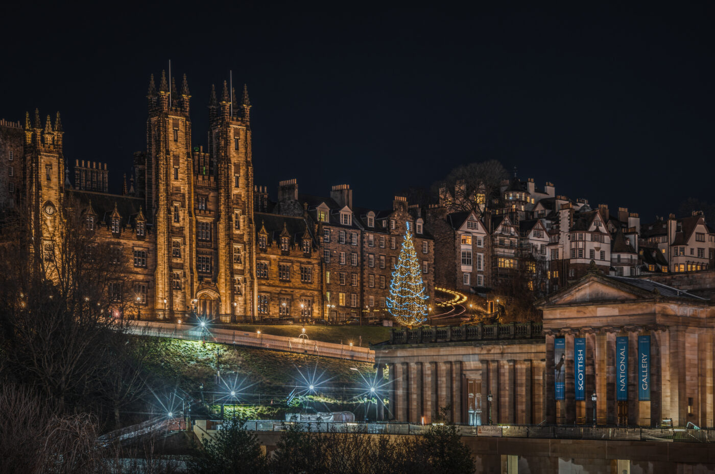 Edinburgh scenic night at Christmas with National Scottish Gallery in the background. The scene is lit with Christmas decorations in Edinburgh.