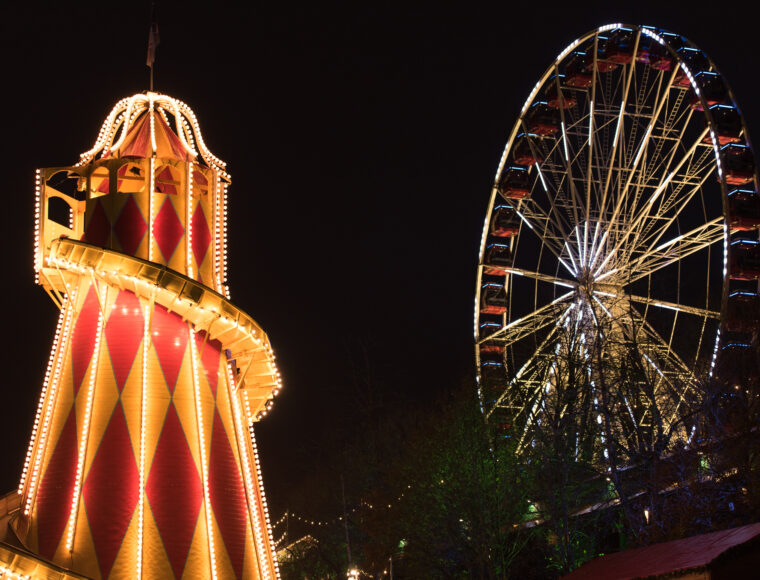 Edinburgh Christmas market at Princes Street with a LED lit ride in the foreground and a ferris wheel in the background.